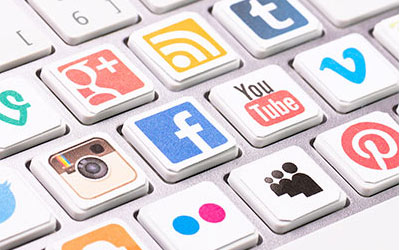 Various social media icons logos on top of keyboard keys
