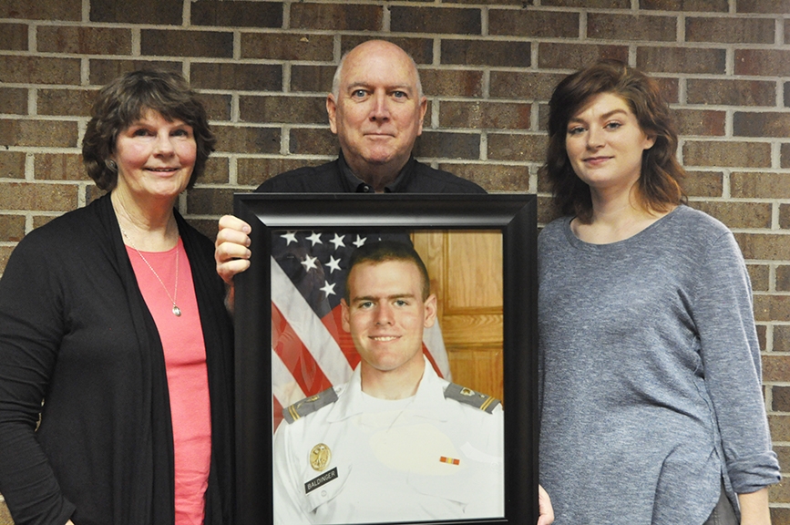 The family of the late Charlie Baldinger including his mother Kim Baldinger, his father Paul Baldinger and his wife Allyson Baldinger pose for a picture with his official West Point Academy portrait. 